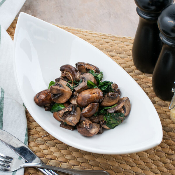 A white bowl with mushrooms and spinach on it.