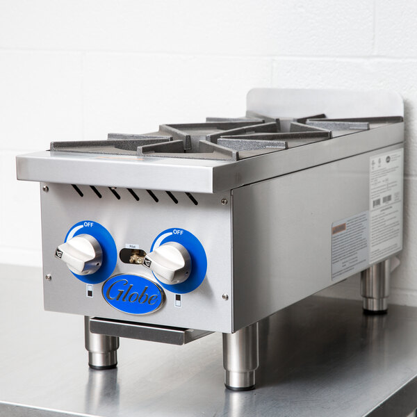 A Globe countertop gas hot plate with blue burners and knobs.