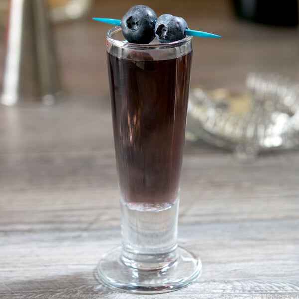 A Libbey Catalina cordial glass filled with a blue drink and blueberries.