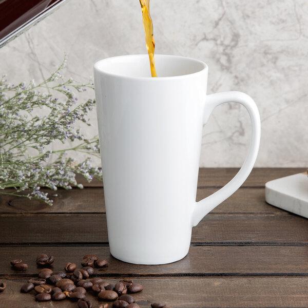A coffee being poured into a white Libbey tall bistro mug.