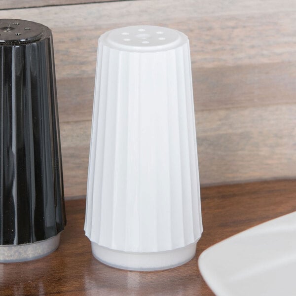 A black and white salt shaker on a table.