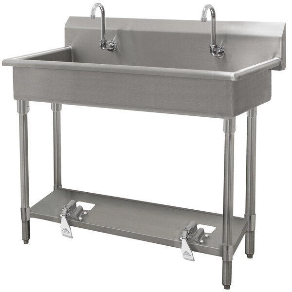 A stainless steel Advance Tabco multi-station hand sink with four toe-operated faucets.