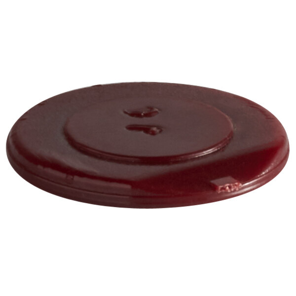 A close-up of a red plastic screw cover.