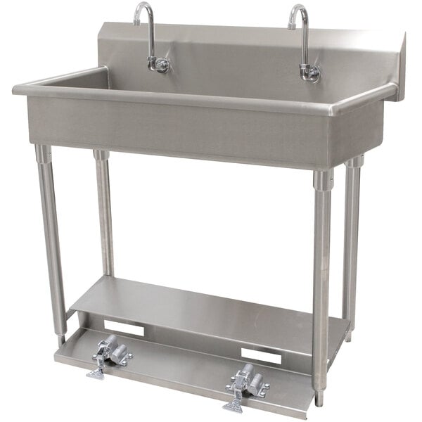 A stainless steel Advance Tabco hand sink with 6 toe operated faucets.
