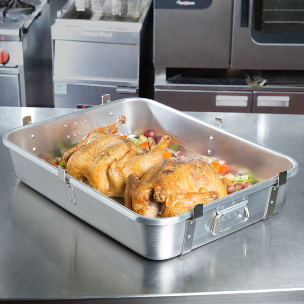 A Vollrath aluminum roaster pan with a roast chicken.