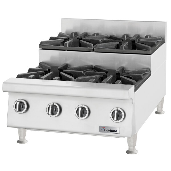 A stainless steel U.S. Range countertop gas range with six black gas burners.