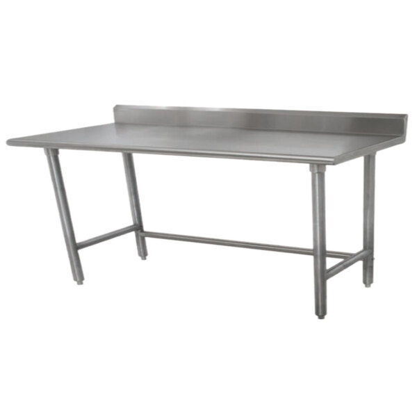 A stainless steel Advance Tabco work table with a backsplash on a stainless steel top.