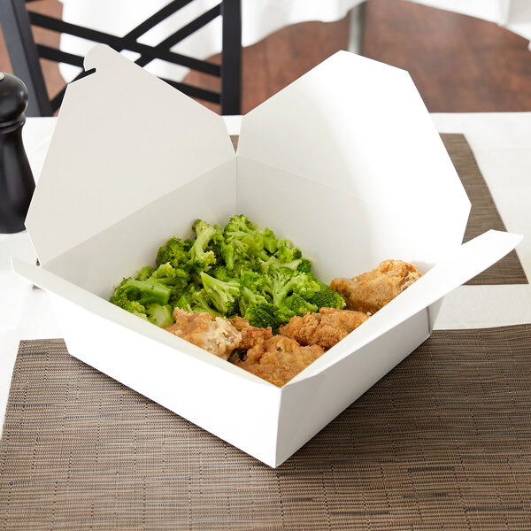 A white Fold-Pak Bio-Pak take-out box on a table with food inside.