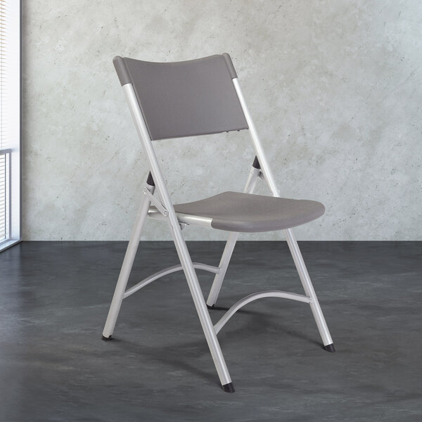 A National Public Seating Silvertone steel folding chair with a gray plastic seat.