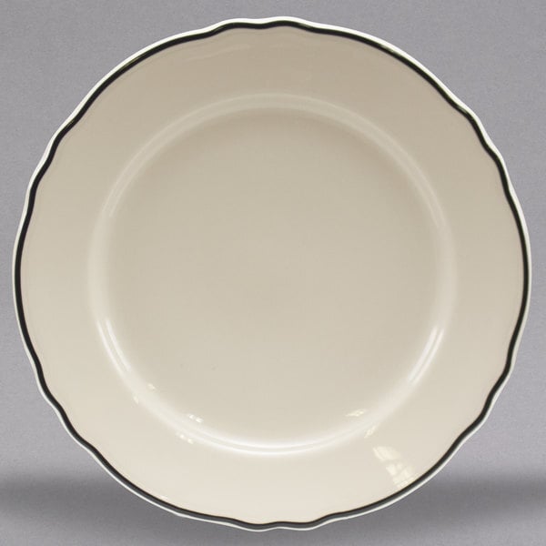A white Homer Laughlin china plate with black scalloped trim.