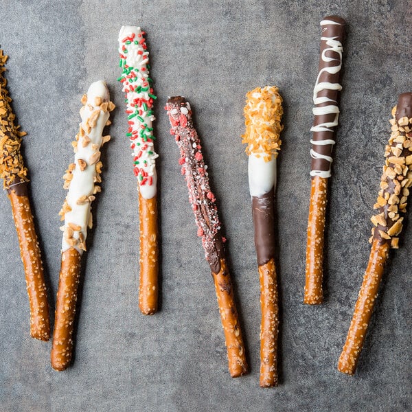 A Snyder's of Hanover chocolate covered pretzel rod with orange and brown sprinkles.