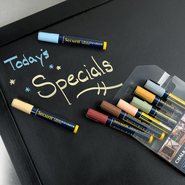 A plastic wrapped pack of American Metalcraft Securit Earth Tone chalk markers on a chalkboard.