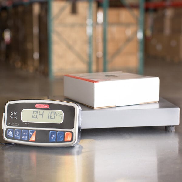 A Tor Rey digital receiving bench scale on a table weighing a box.
