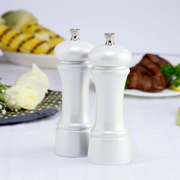 A Chef Specialties Elegance Pearl Metallic pepper mill and salt mill set on a table.