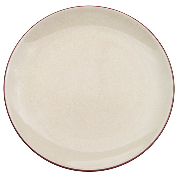 A CAC creamy white stoneware coupe plate with a red rim.