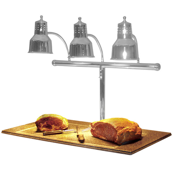 A Hanson Heat Lamps stainless steel carving station with three bulbs over meat on a counter.