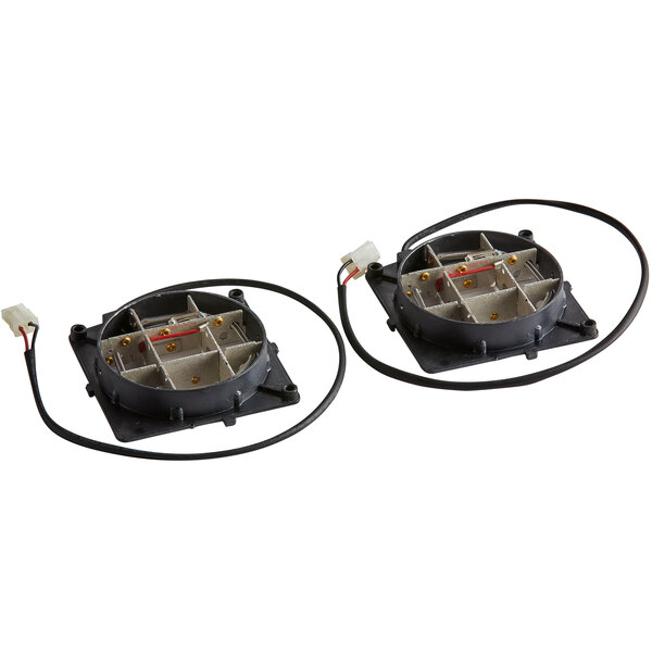A black metal heater assembly with two white rectangular objects inside.