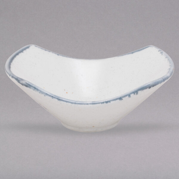 A white porcelain bowl with blue rim and blue and white designs.