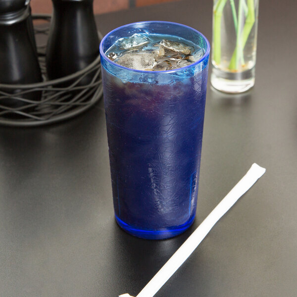 A blue drink with ice and a straw in a Cambro Del Mar blue plastic tumbler.