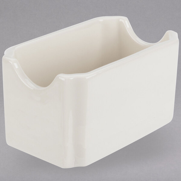 A white rectangular china sugar caddy with a curved edge.