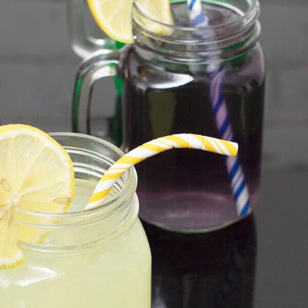 Two mason jars with Creative Converting yellow and white paper straws and lemon slices.