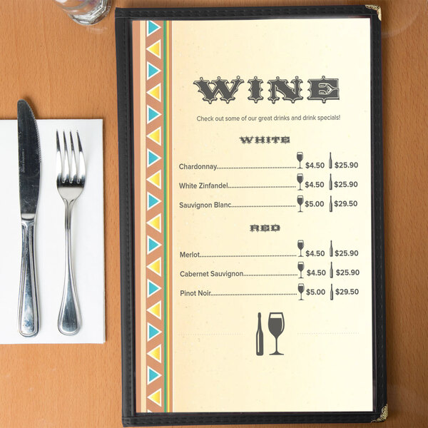 Menu paper with a southwest fiesta border design on a table with wine glasses and a knife and fork.