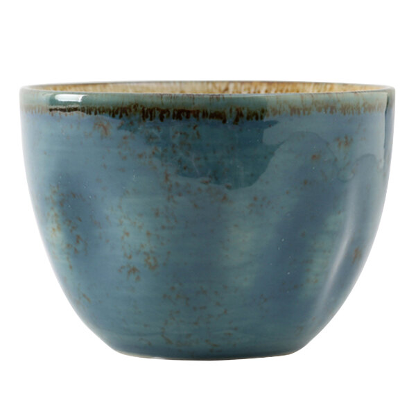 A close up of a Tuxton Artisan Geode Azure bouillon cup, a blue bowl with brown specks.