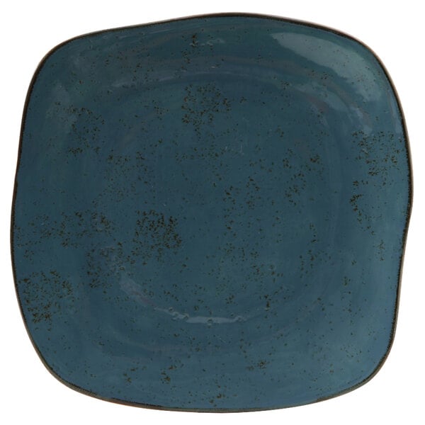 A blue square Tuxton china plate with a black speckled design.