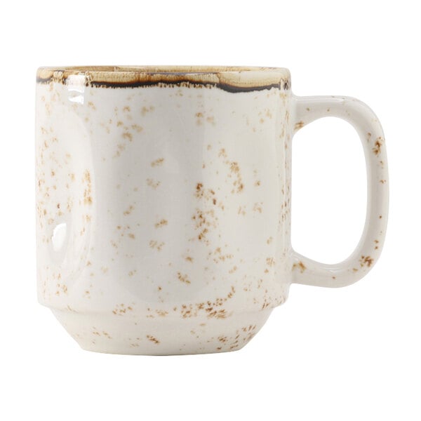 A white china mug with brown speckles and a white and brown handle.