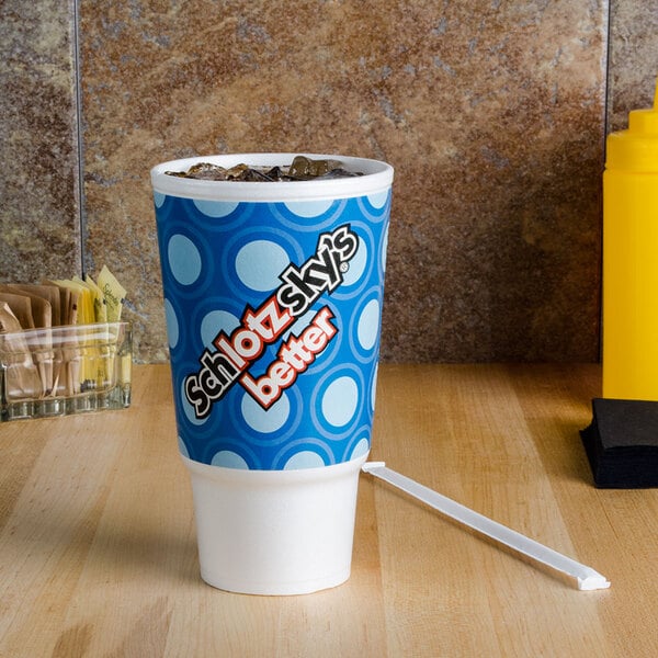 A white Dart foam cup with blue and white circles on it.
