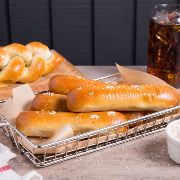 A basket filled with Dutch Country Foods soft pretzel sticks on a table in a bakery display.