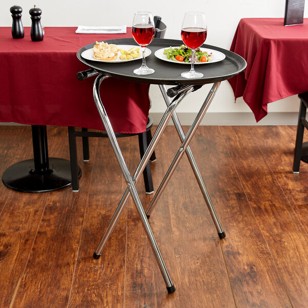 A Tablecraft chrome-plated metal tray stand with food and wine on a table.