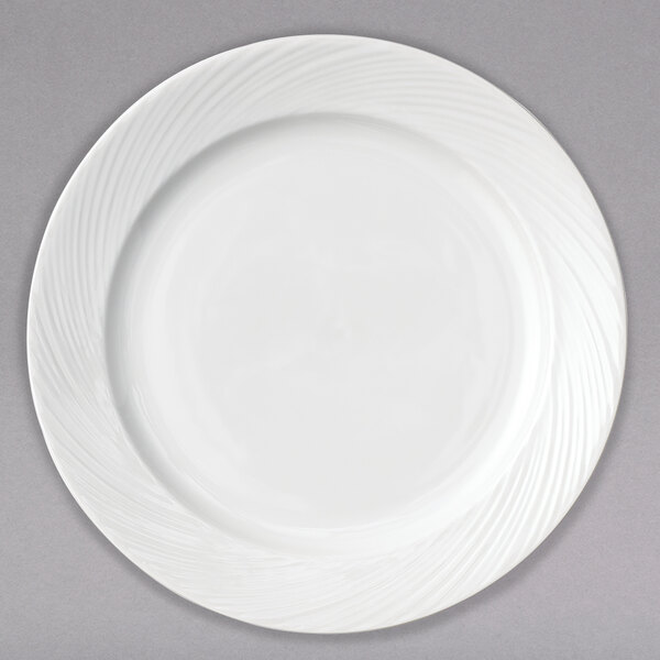 A close-up of a white Arcoroc porcelain side plate with a wavy design.