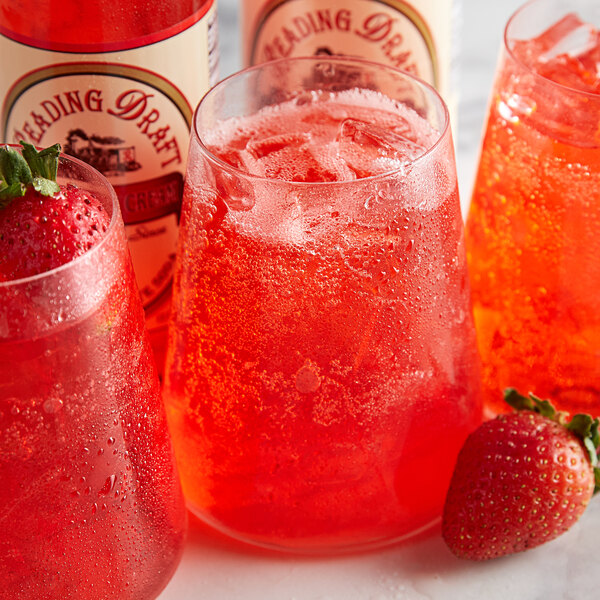 A group of glasses of Reading Soda Works Strawberry Cream with ice and strawberries.