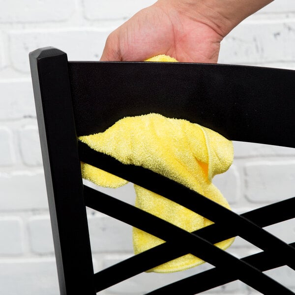 A hand holding a yellow Unger SmartColor medium-duty microfiber cleaning cloth.