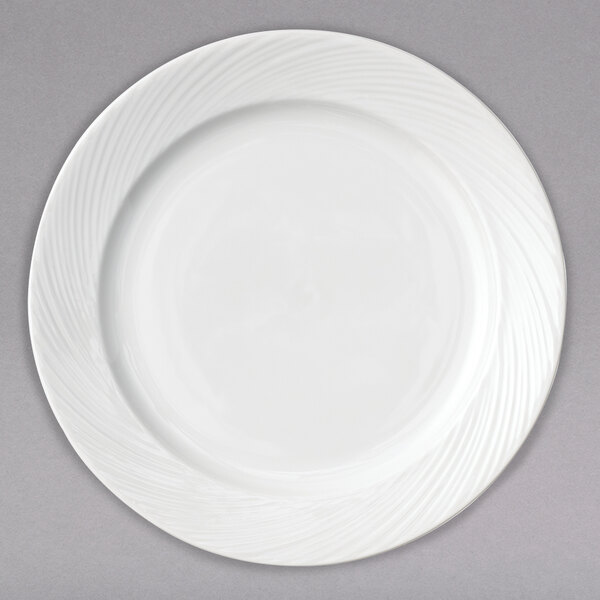 A close-up of an Arcoroc white porcelain salad plate with a wavy design.