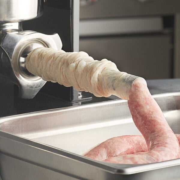 A sausage being processed in a butcher shop.