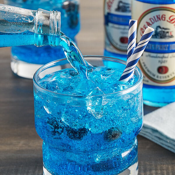 A blue Reading Soda Works Blueberry Birch Beer being poured into a glass with a blue and white striped straw.