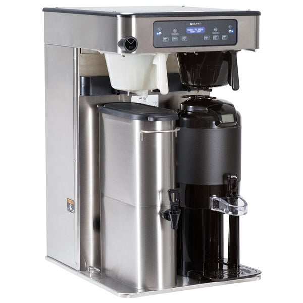 A Bunn ITCB Infusion coffee and tea brewer on a counter with a black screen and containers.