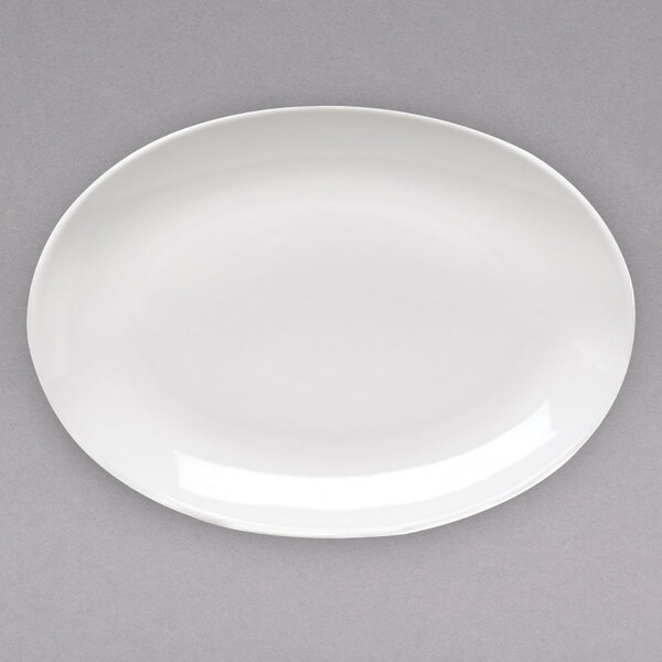 A white porcelain oval platter with a white rim on a gray surface.