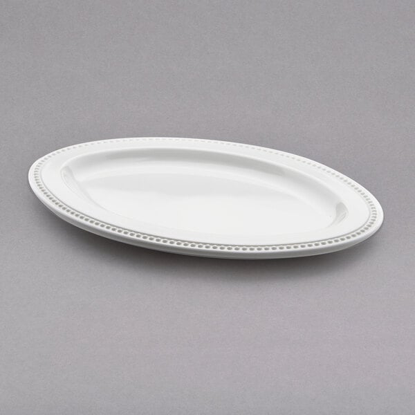 A white oval melamine plate with a beaded rim.