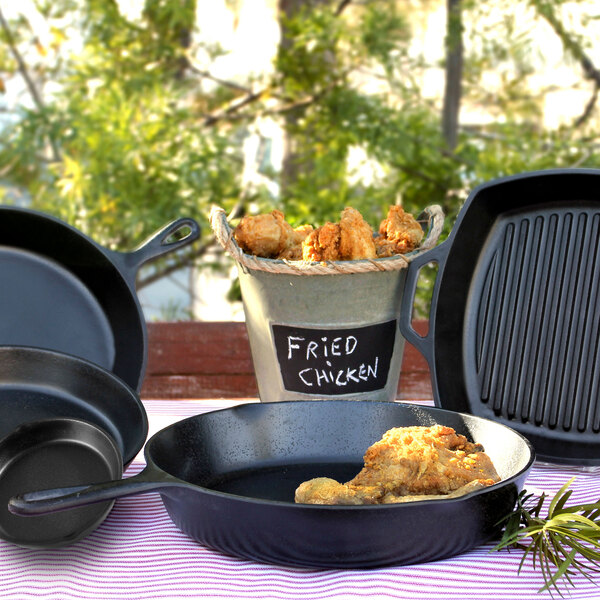 A close-up of a black faux cast iron Elite Global Solutions frying pan with food in it.