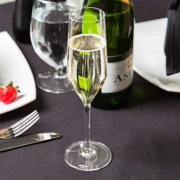 A glass of champagne sits on a table in a fine dining restaurant.