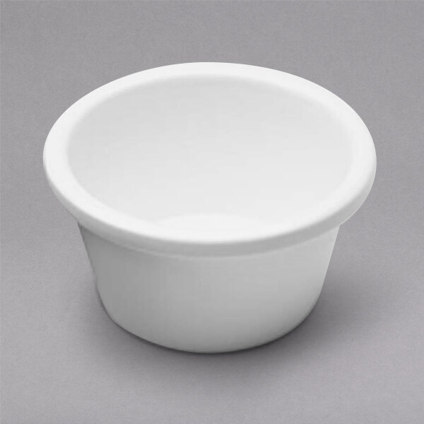 A close up of a white Elite Global Solutions melamine ramekin with a white rim.
