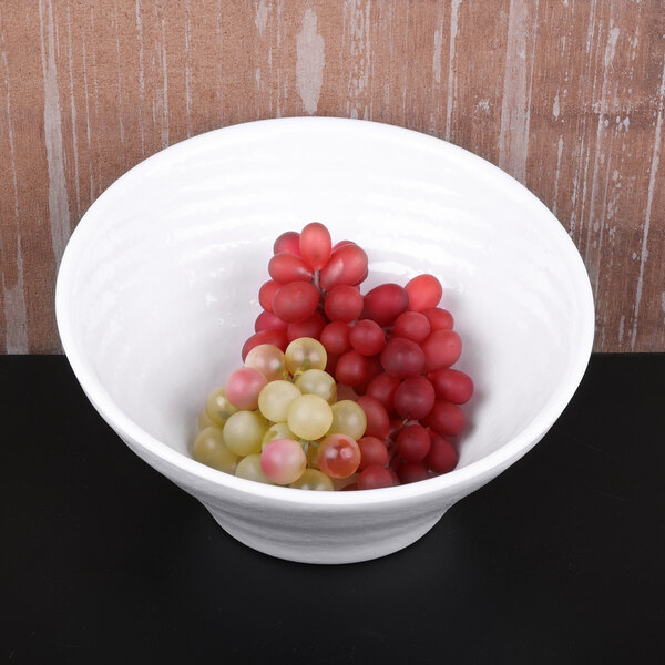 A white Elite Global Solutions Durango melamine bowl filled with grapes on a table.