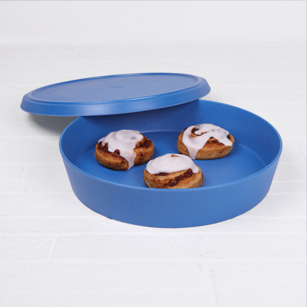 A blue container with a lid and three cinnamon rolls inside.
