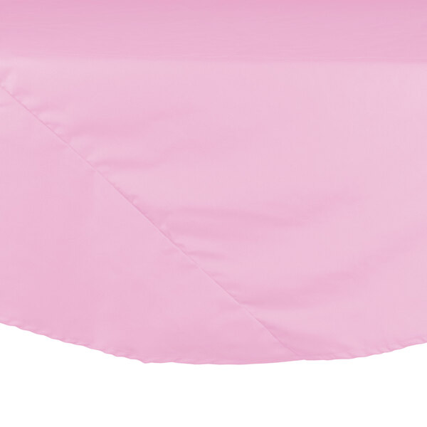 A pink Intedge poly/cotton blend round tablecloth on a table.