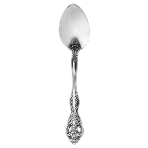A Oneida Michelangelo stainless steel teaspoon with an ornate handle.