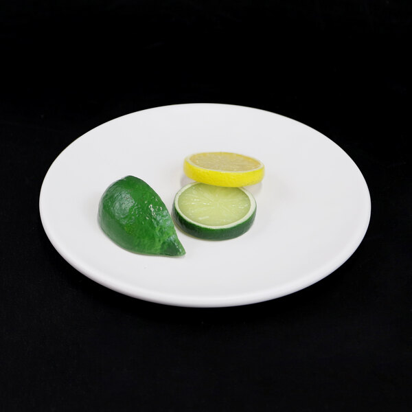 An Elite Global Solutions off white melamine plate with lime and lemon slices on it.