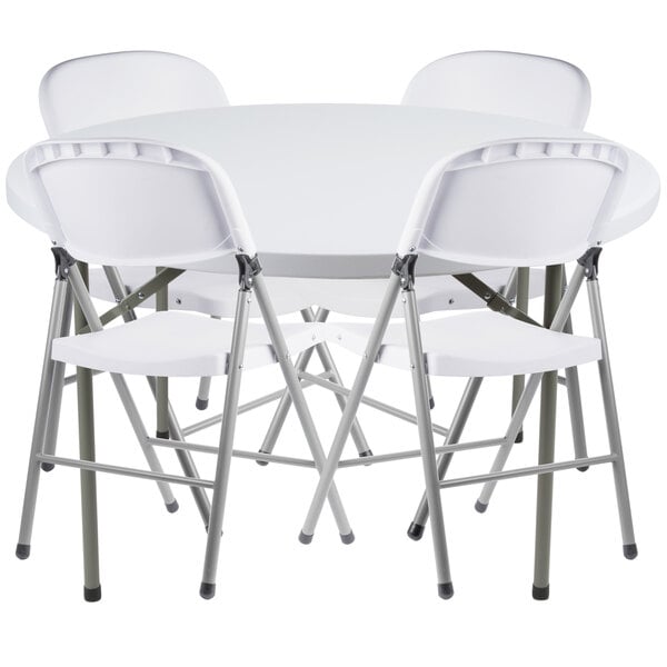 A white folding table with four white chairs.
